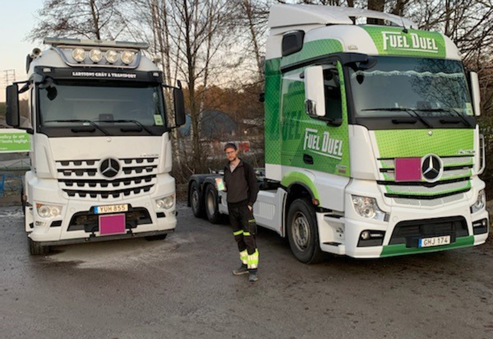 Olof från Larssons Gräv & Transport AB mellan två av åkeriets lastbilar. Åkeriet är en av Workifys åkerikunder.