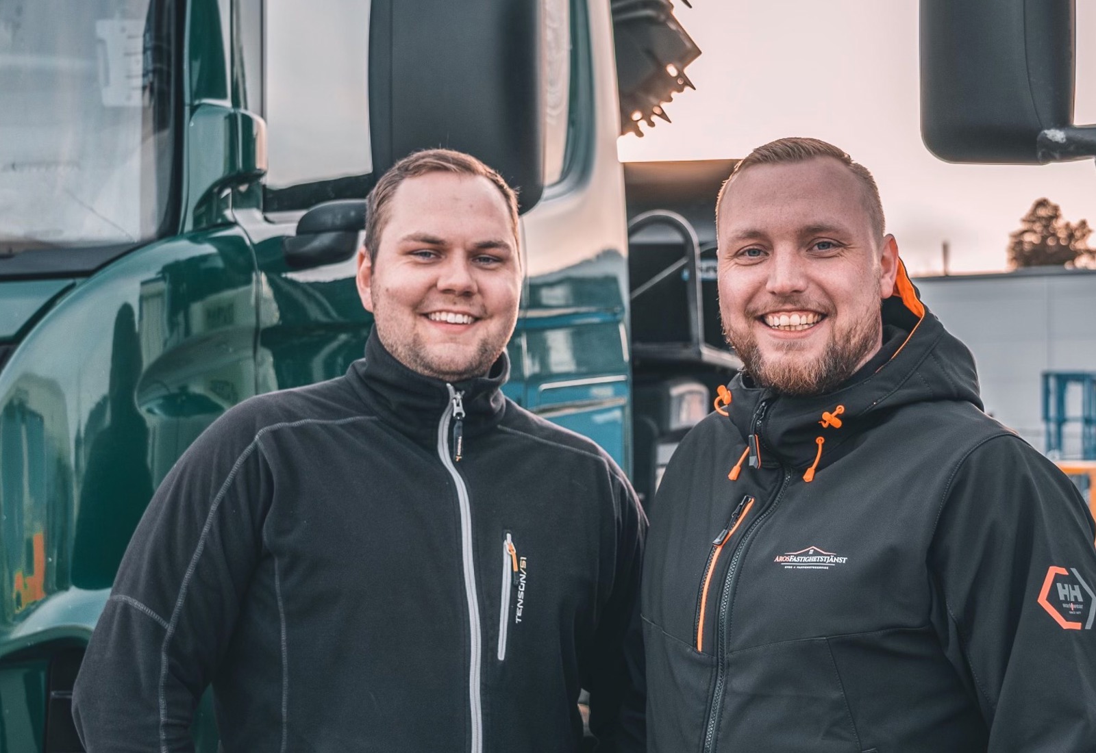 Erik Sors med kollega från åkeriet Sors & Ljunggren Transport,  framför några av sina lastbilar. Åkeriet använder Workify.